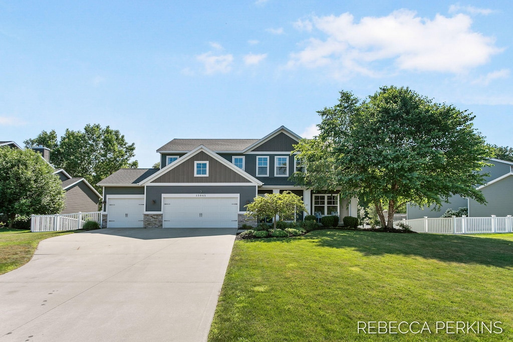 15045 Silver Fir Dr, Holland, MI 49424 - craftsman-style house featuring a garage, driveway, stone siding, and board and batten siding