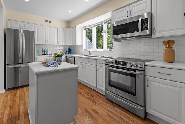 1618 Birmingham Blvd, Birmingham, MI 48009 - kitchen featuring appliances with stainless steel finishes, white cabinetry, backsplash, a center island, and recessed lighting