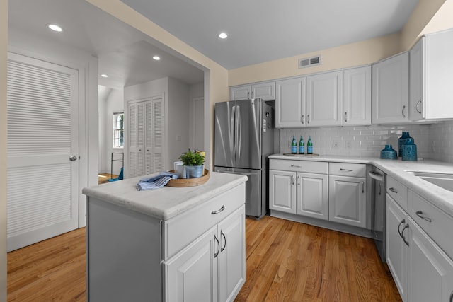 1618 Birmingham Blvd, Birmingham, MI 48009 - kitchen featuring stainless steel appliances, backsplash, light wood finished floors, a center island, and white cabinets