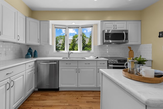 1618 Birmingham Blvd, Birmingham, MI 48009 - kitchen featuring appliances with stainless steel finishes, light wood-type flooring, tasteful backsplash, and white cabinetry