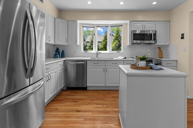 1618 Birmingham Blvd, Birmingham, MI 48009 - kitchen with stainless steel appliances, light wood-type flooring, recessed lighting, backsplash, and a kitchen island