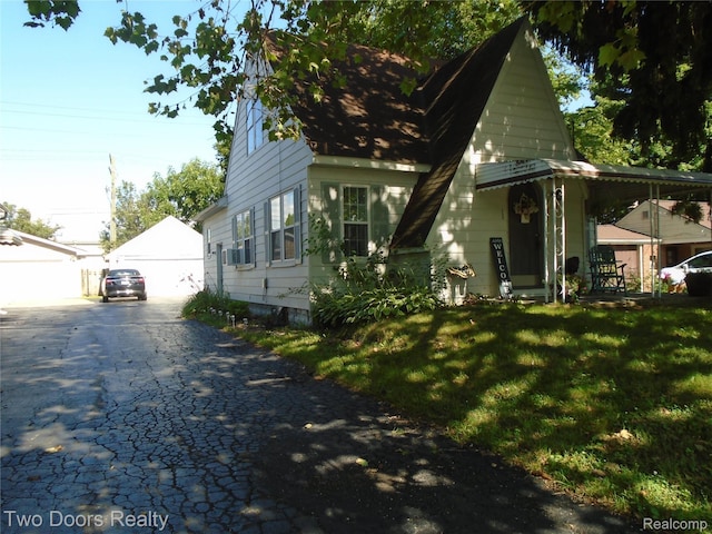 view of front facade featuring a front yard, an outbuilding, and a garage