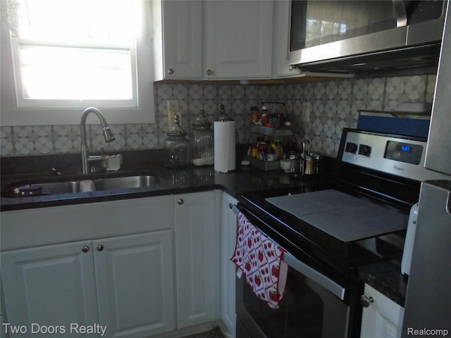 kitchen with appliances with stainless steel finishes, white cabinets, dark countertops, and decorative backsplash