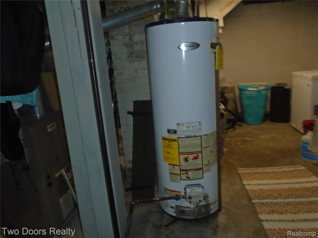 utility room with water heater and washer / dryer