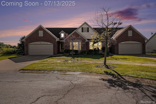 7031 Iris Ct Unit 3, Grand Blanc, MI 48439 - view of front of home with concrete driveway, brick siding, a lawn, and an attached garage