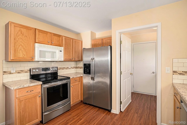 7031 Iris Ct Unit 3, Grand Blanc, MI 48439 - kitchen with stainless steel appliances, dark wood-style flooring, tasteful backsplash, and light stone countertops
