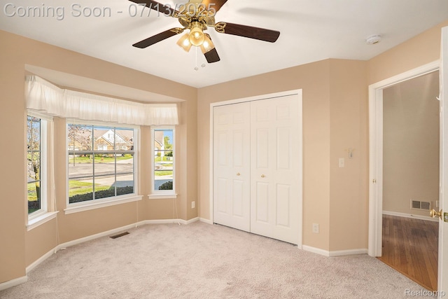 7031 Iris Ct Unit 3, Grand Blanc, MI 48439 - unfurnished bedroom featuring carpet floors, a closet, and a ceiling fan