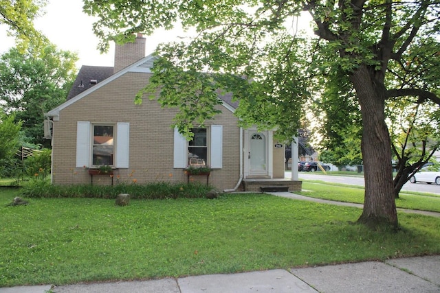 2906 Syracuse St, Dearborn, MI 48124 - view of front facade featuring brick siding, a front lawn, a chimney, and roof with shingles
