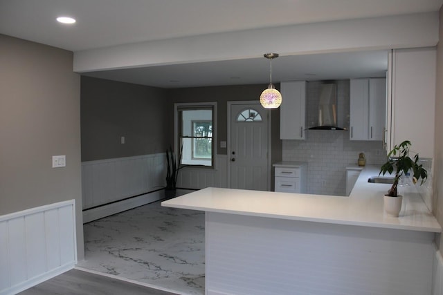 2906 Syracuse St, Dearborn, MI 48124 - kitchen featuring wall chimney exhaust hood, a peninsula, a wainscoted wall, pendant lighting, and light countertops