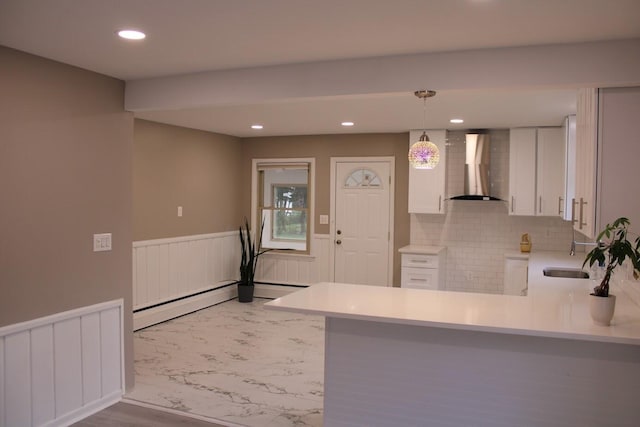 2906 Syracuse St, Dearborn, MI 48124 - kitchen with wall chimney exhaust hood, a peninsula, white cabinetry, light countertops, and pendant lighting