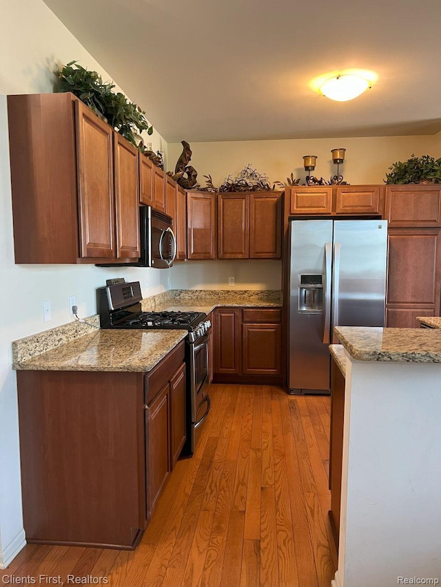 1082 Paddock Dr Unit 78, South Lyon, MI 48178 - kitchen with appliances with stainless steel finishes, light wood-type flooring, and light stone countertops
