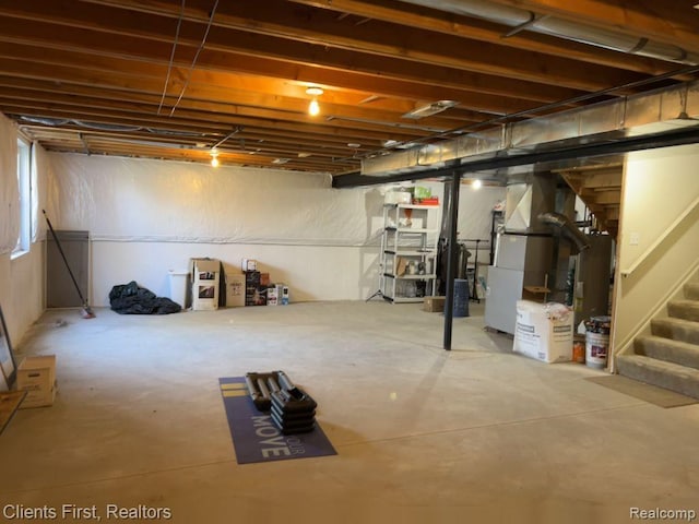 1082 Paddock Dr Unit 78, South Lyon, MI 48178 - below grade area featuring heating unit, stairway, and gas water heater