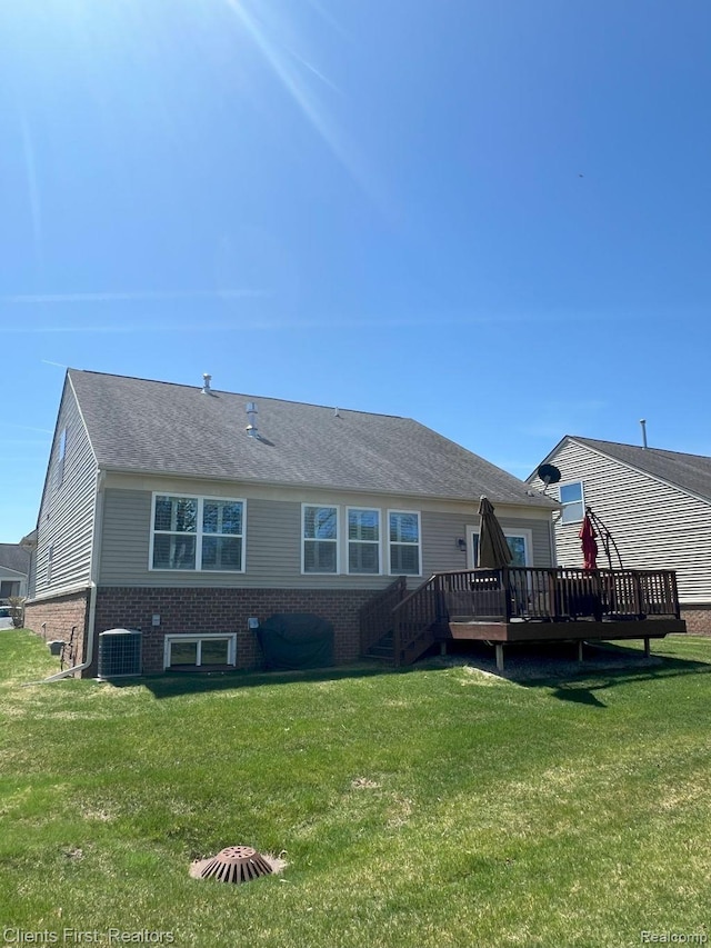 1082 Paddock Dr Unit 78, South Lyon, MI 48178 - back of property with a deck, a lawn, brick siding, and stairs