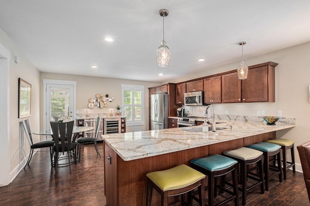 330 Rachaels Way, Spring Lake, MI 49456 - kitchen featuring appliances with stainless steel finishes, dark wood-type flooring, light stone counters, recessed lighting, and a peninsula