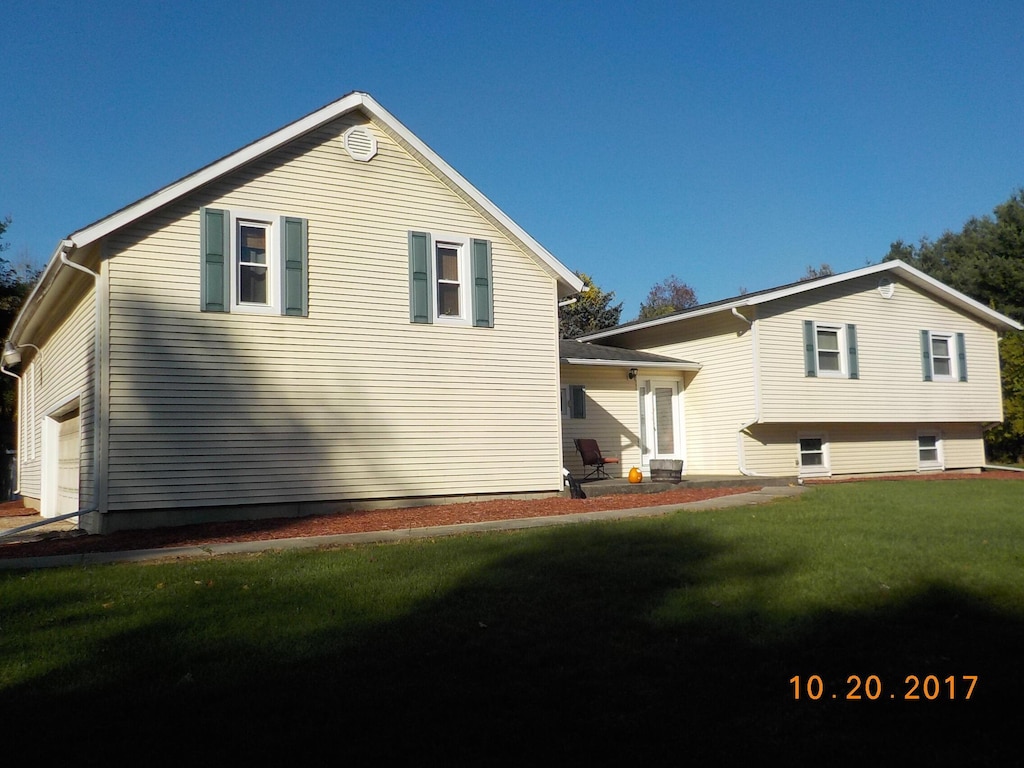 11867 4 Mile Rd, Battle Creek, MI 49015 - view of home's exterior with a yard and a garage