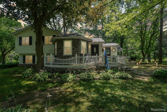 3439 N Mill Rd, Dryden, MI 48428 - view of front of property featuring a wooden deck, stone siding, and a front lawn