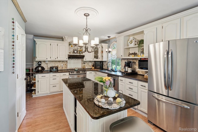 3439 N Mill Rd, Dryden, MI 48428 - kitchen with appliances with stainless steel finishes, a chandelier, open shelves, backsplash, and a center island