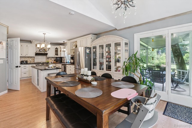 3439 N Mill Rd, Dryden, MI 48428 - dining space featuring a chandelier, light wood-style floors, and vaulted ceiling