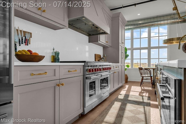 2051 Villa Rd Unit 302, Birmingham, MI 48009 - kitchen with range with two ovens, premium range hood, wood finished floors, and recessed lighting