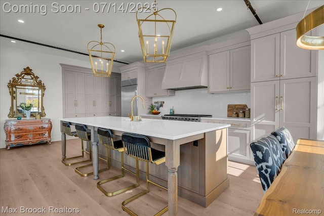 2051 Villa Rd Unit 302, Birmingham, MI 48009 - kitchen featuring custom range hood, stainless steel built in fridge, light countertops, a chandelier, and light wood-type flooring