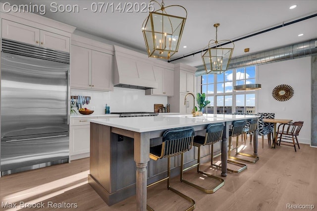2051 Villa Rd Unit 302, Birmingham, MI 48009 - kitchen with built in refrigerator, custom exhaust hood, light wood-type flooring, a chandelier, and recessed lighting