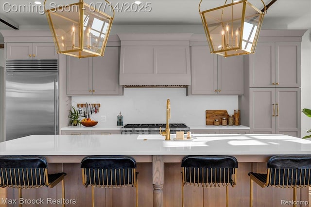 2051 Villa Rd Unit 302, Birmingham, MI 48009 - kitchen with stainless steel built in fridge, custom exhaust hood, a breakfast bar area, light countertops, and hanging light fixtures