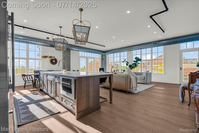 2051 Villa Rd Unit 302, Birmingham, MI 48009 - kitchen featuring plenty of natural light, a kitchen island with sink, wood finished floors, and recessed lighting