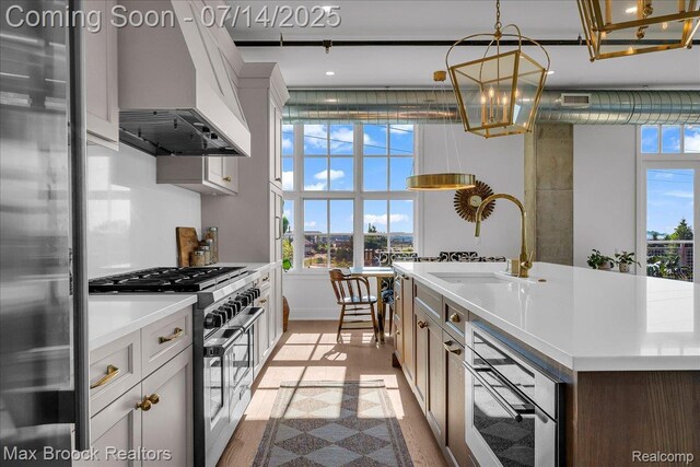 2051 Villa Rd Unit 302, Birmingham, MI 48009 - kitchen featuring high end appliances, custom range hood, a chandelier, and healthy amount of natural light