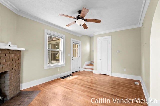 1340 Ashland Ave NE, Grand Rapids, MI 49505 - unfurnished living room with wood finished floors, crown molding, a fireplace, a ceiling fan, and a textured ceiling