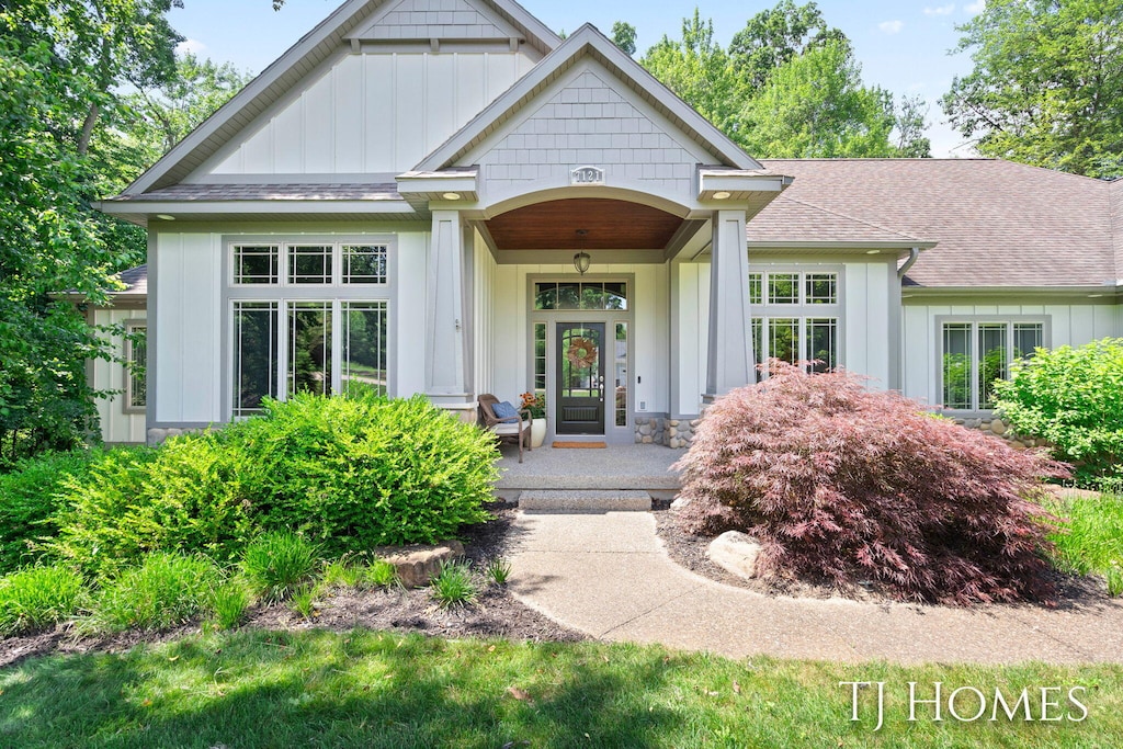 7121 Juneau Ct SE, Caledonia, MI 49316 - entrance to property featuring board and batten siding, a shingled roof, and a porch