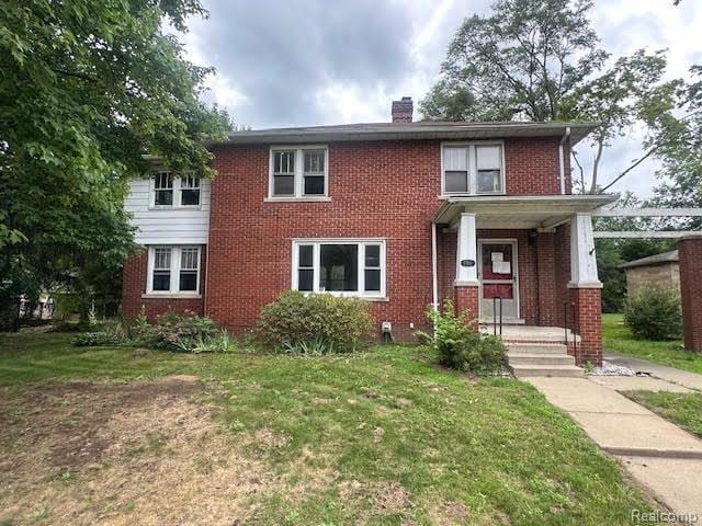 12100 Elmview St, Romulus, MI 48174 - view of front of property with a chimney, brick siding, and a front lawn