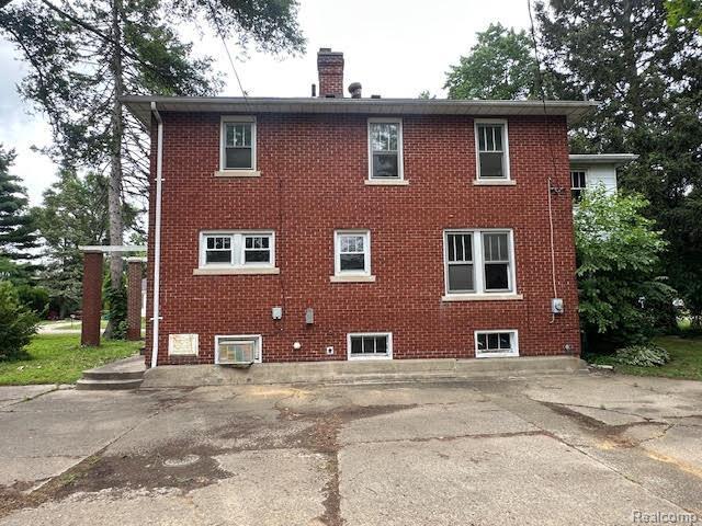 12100 Elmview St, Romulus, MI 48174 - back of property featuring a chimney and brick siding