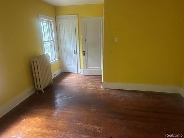 12100 Elmview St, Romulus, MI 48174 - unfurnished room featuring radiator heating unit and wood finished floors