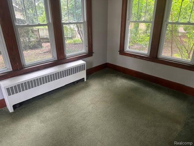 12100 Elmview St, Romulus, MI 48174 - carpeted empty room featuring radiator heating unit and healthy amount of natural light