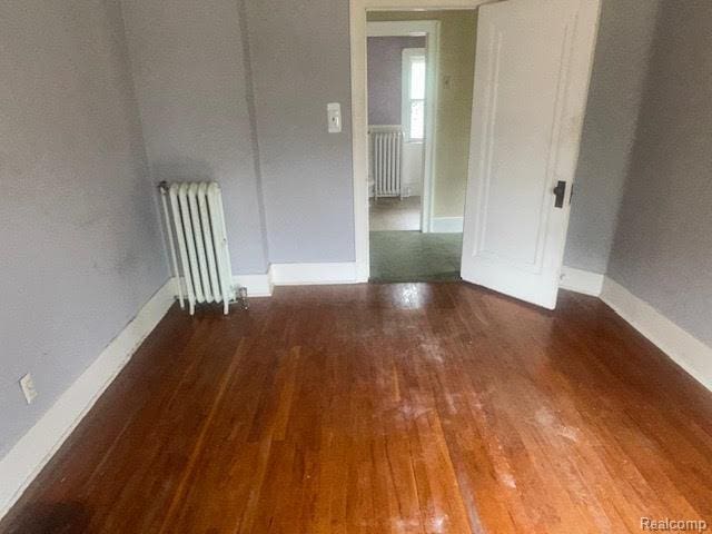 12100 Elmview St, Romulus, MI 48174 - unfurnished room with radiator heating unit and wood finished floors