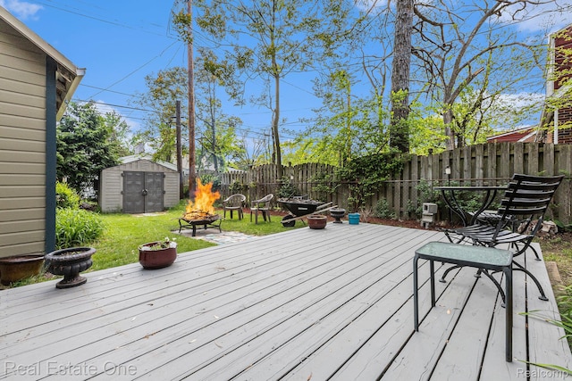 35451 John St, Wayne, MI 48184 - wooden terrace featuring a fire pit, a storage shed, and a fenced backyard