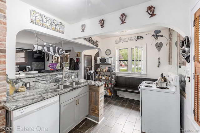35451 John St, Wayne, MI 48184 - kitchen featuring white appliances, arched walkways, light stone countertops, and wood finish floors