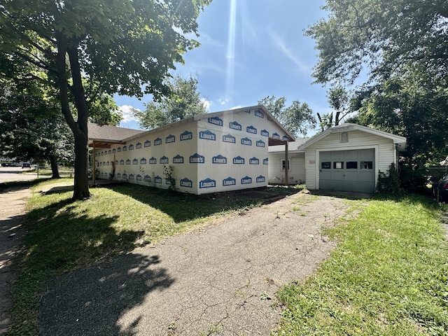 1820 Elgin St, Kalamazoo, MI 49001 - view of home's exterior featuring asphalt driveway, an outdoor structure, and a yard