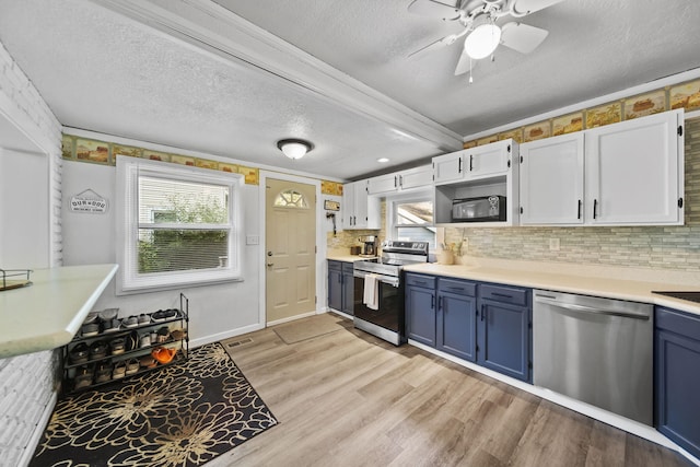 350 N Horton St, Jackson, MI 49202 - kitchen featuring stainless steel appliances, blue cabinets, a textured ceiling, light wood-style flooring, and tasteful backsplash