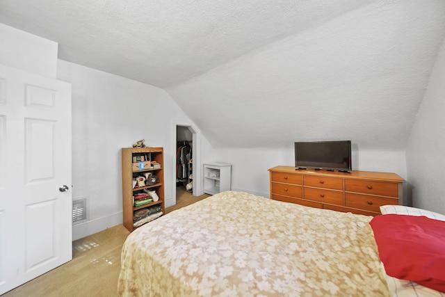 350 N Horton St, Jackson, MI 49202 - bedroom with vaulted ceiling, a textured ceiling, and a walk in closet