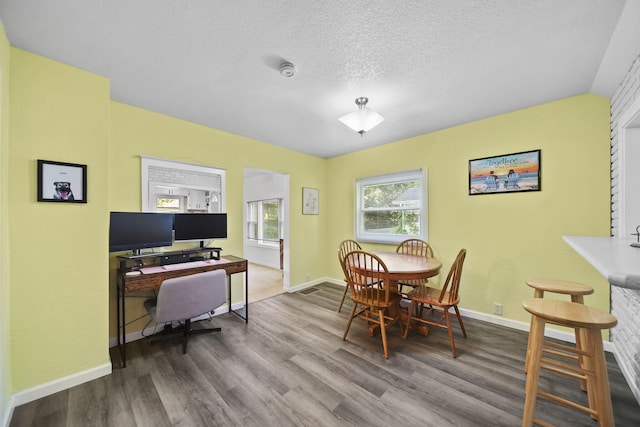 350 N Horton St, Jackson, MI 49202 - dining area with wood finished floors, a desk, and a textured ceiling