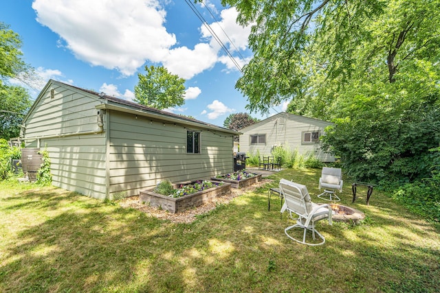 471 Dupont Ave, Ypsilanti, MI 48197 - back of house featuring an outdoor fire pit, a yard, and a garden