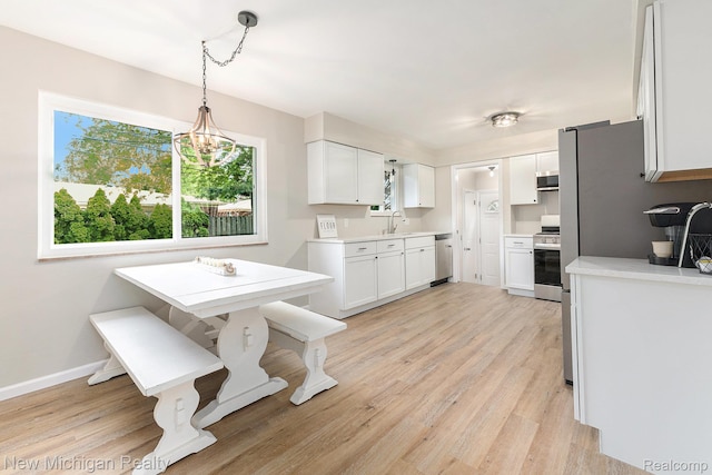 23306 Greencrest St, Saint Clair Shores, MI 48080 - kitchen with stainless steel appliances, white cabinets, light wood finished floors, and light countertops