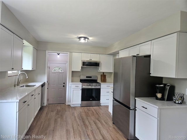 23306 Greencrest St, Saint Clair Shores, MI 48080 - kitchen with appliances with stainless steel finishes, light wood-style flooring, and white cabinetry