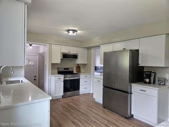 23306 Greencrest St, Saint Clair Shores, MI 48080 - kitchen featuring stainless steel appliances, white cabinetry, and light wood-style floors