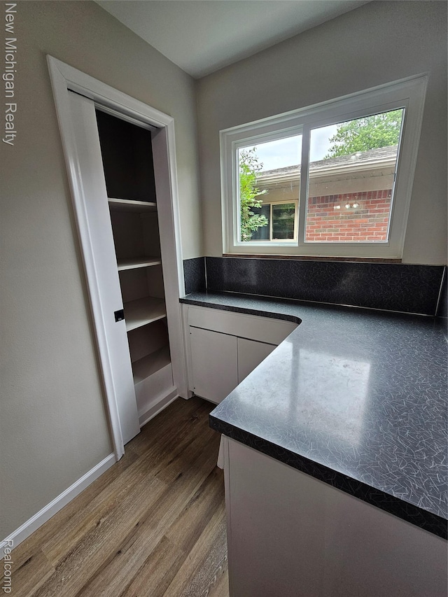 23306 Greencrest St, Saint Clair Shores, MI 48080 - kitchen featuring dark countertops, wood finished floors, and white cabinets
