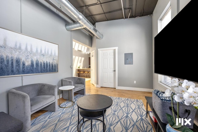 139 Pearl St NW, Grand Rapids, MI 49503 - living area with electric panel, a towering ceiling, and light wood-style flooring