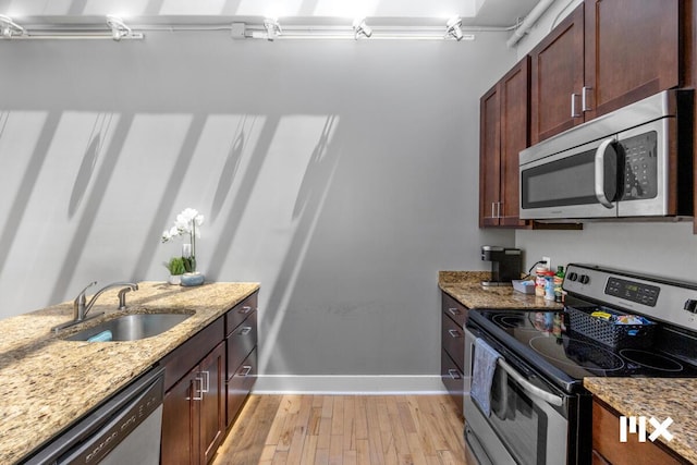 139 Pearl St NW, Grand Rapids, MI 49503 - kitchen featuring appliances with stainless steel finishes, light wood-type flooring, and light stone countertops