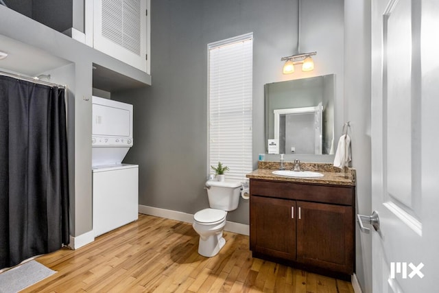 139 Pearl St NW, Grand Rapids, MI 49503 - bathroom with stacked washing machine and dryer, wood finished floors, vanity, and a shower with shower curtain