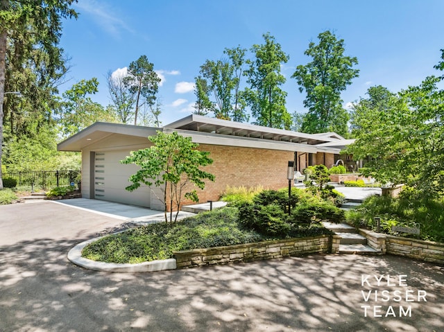 130 Robinwood Ave SE, Grand Rapids, MI 49506 - view of side of home featuring driveway, brick siding, and a garage